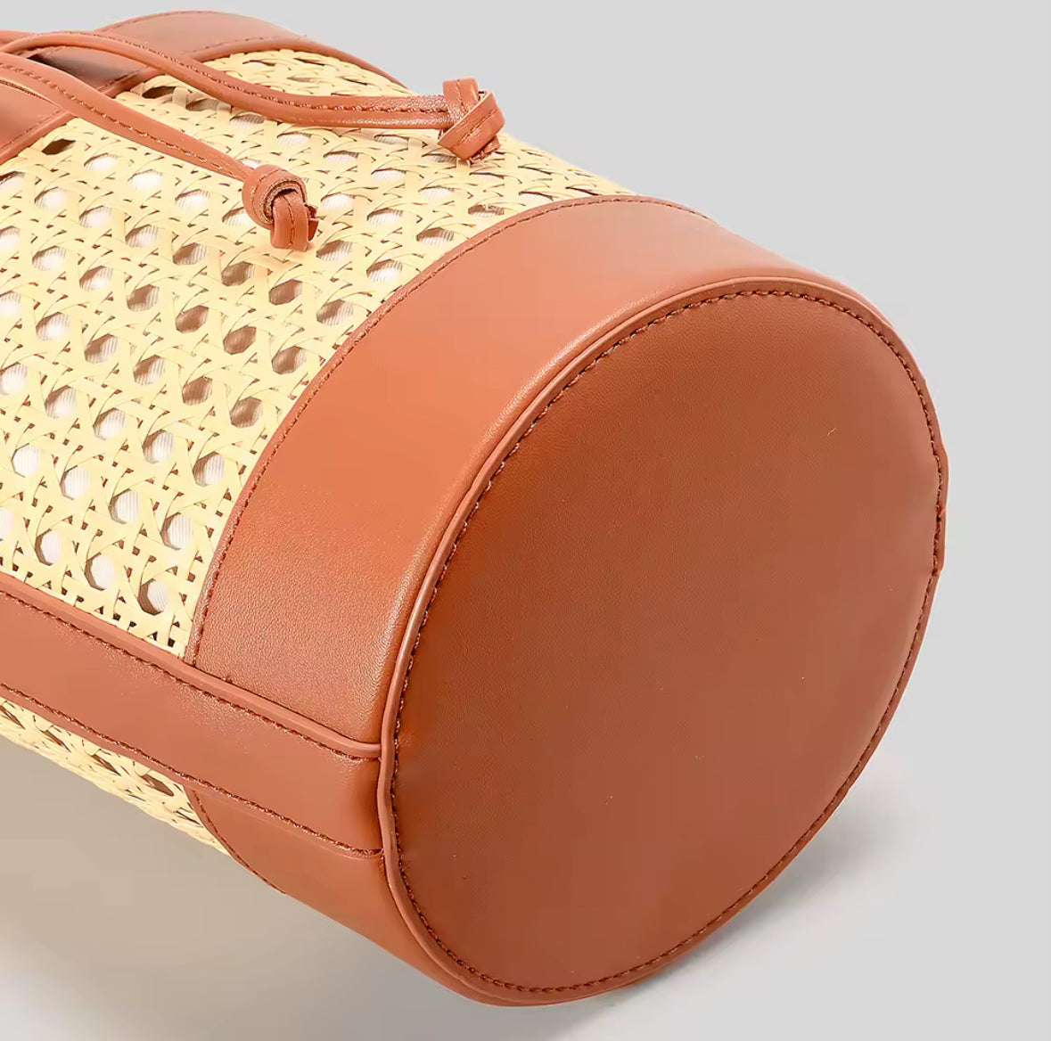 Sac en rotin tressé avec fermeture en cuir, idéal pour un style naturel et authentique. seau en rotin