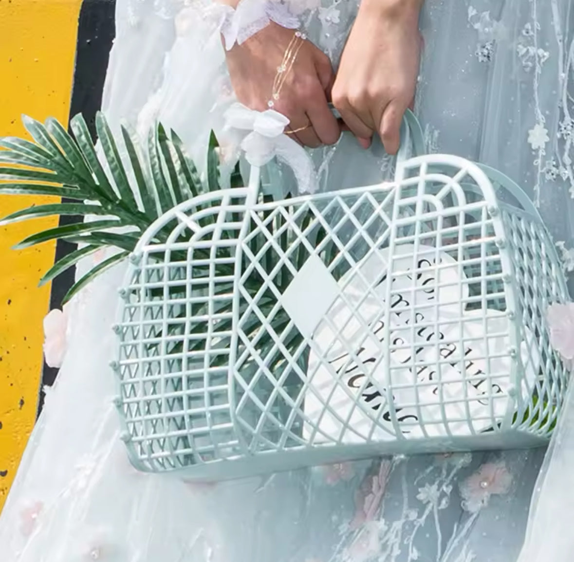 Panier plastique rétro vert menthe utilisé en extérieur avec feuillage tropical