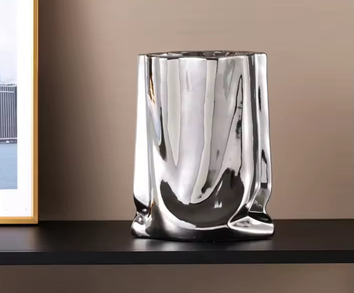 Vase chromé contemporain posé sur une table design – accessoire déco élégant
