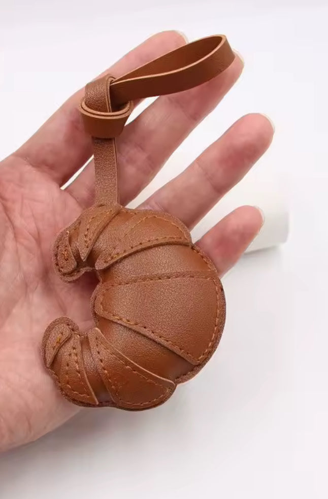 Porte-clés croissant en similicuir marron dans la main accessoire mode