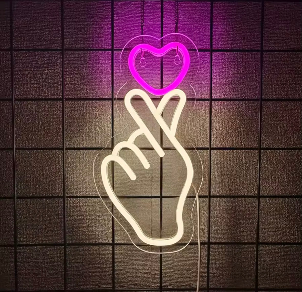 Néon LED mural main et cœur rose allumé sur mur intérieur moderne