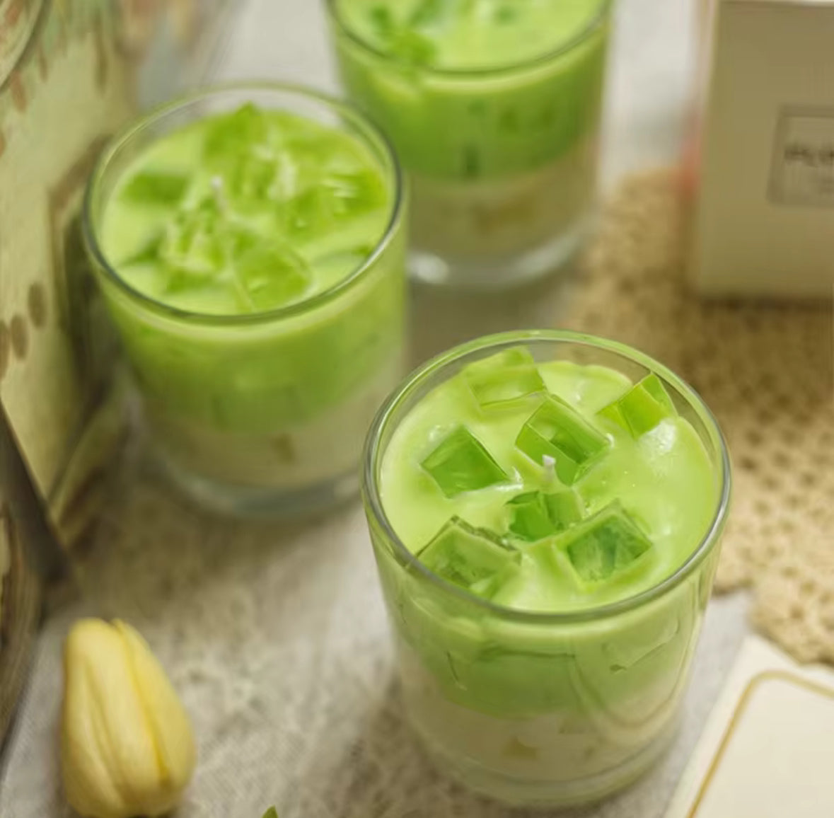 Bougie artisanale Matcha Latte dans un verre transparent, effet réaliste de latte glacé au matcha, bougie décorative éco-responsable.