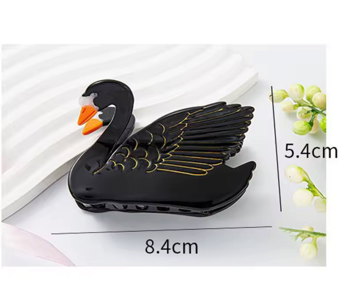 Pince cygne noir posée sur tissu – accessoire raffiné pour cheveux
