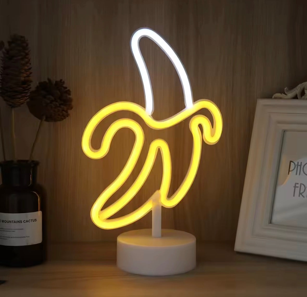 Lampe néon banane design pop posée sur meuble, éclairage décoratif d’ambiance