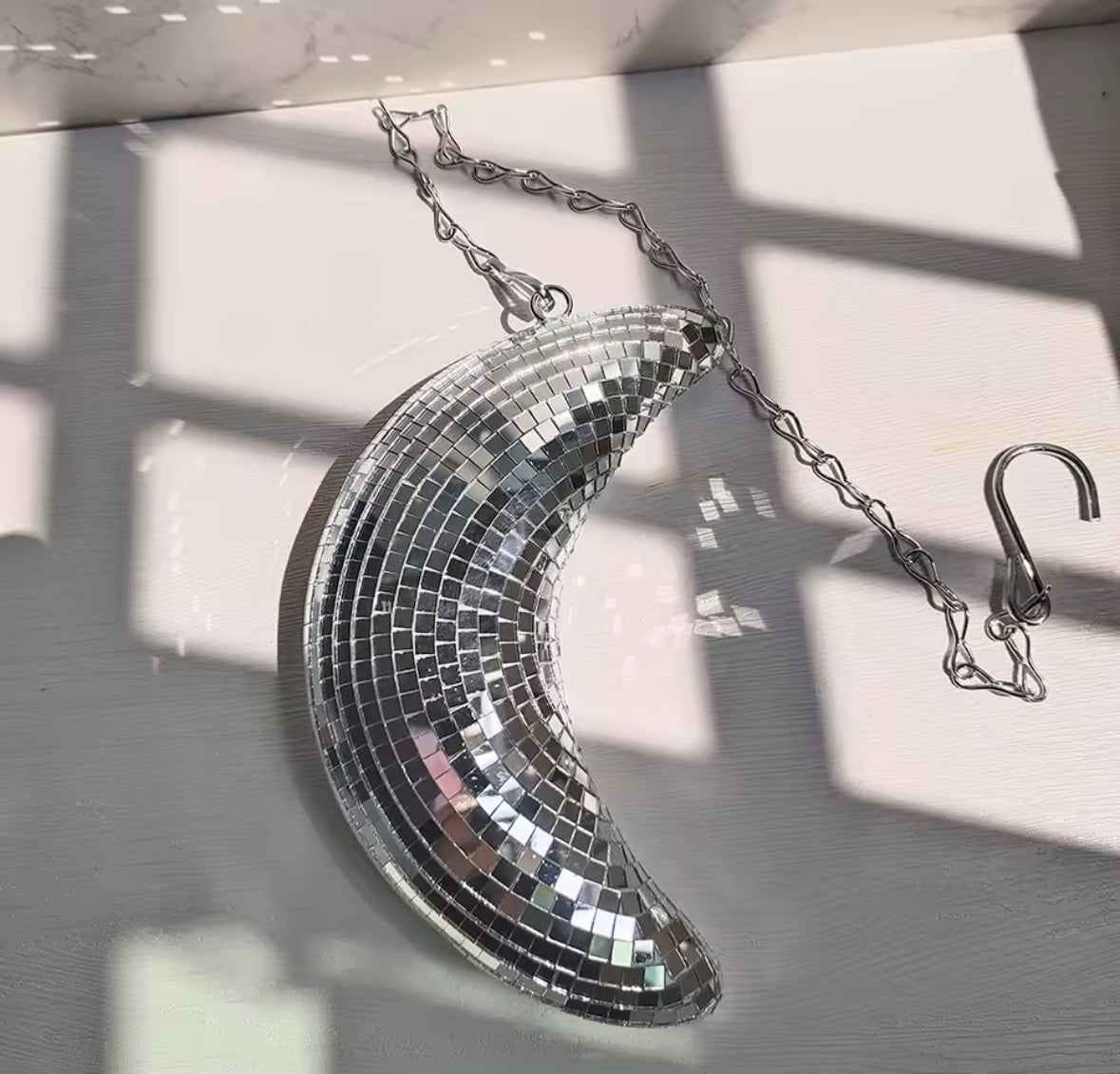 Suspension croissant de lune miroir pleine surface style boule disco pour intérieur moderne.