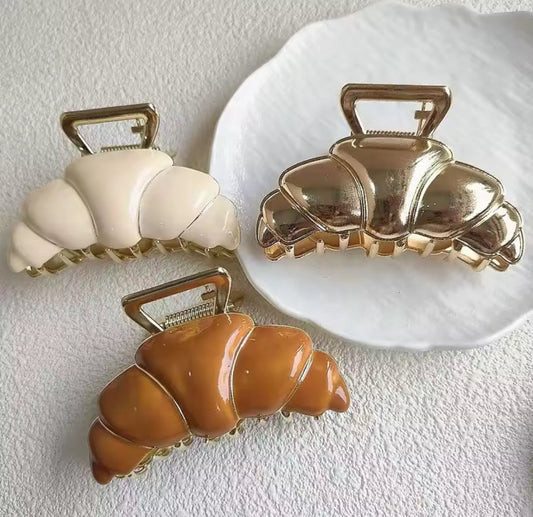 Pince à cheveux croissant couleur caramel tenue en main
